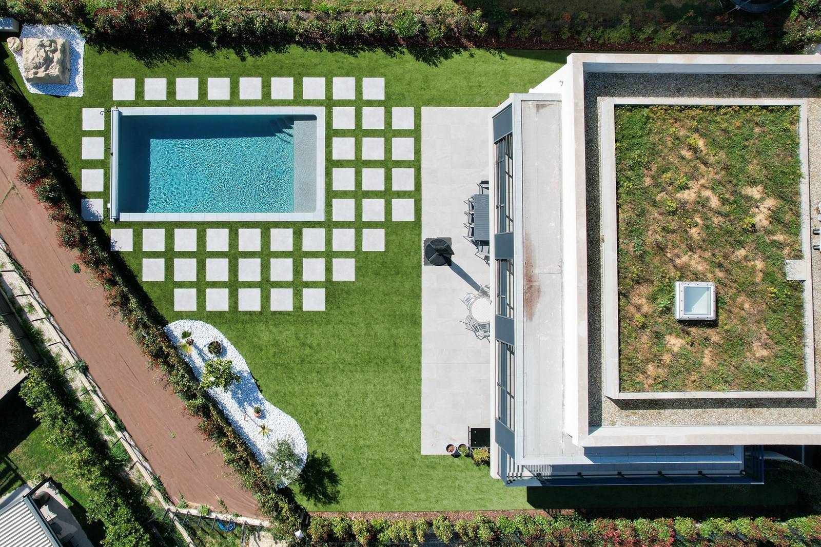 Aménagement haut de gamme d'un jardin à La Roquette avec contour de piscine mixant gazon synthétique et grande dalles grise de carreau