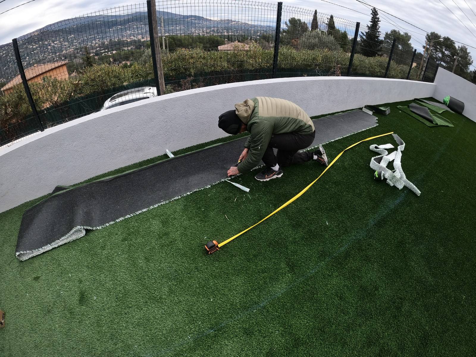 Pose et découpe des lés de gazon synthétique pour notre client à Peyménade