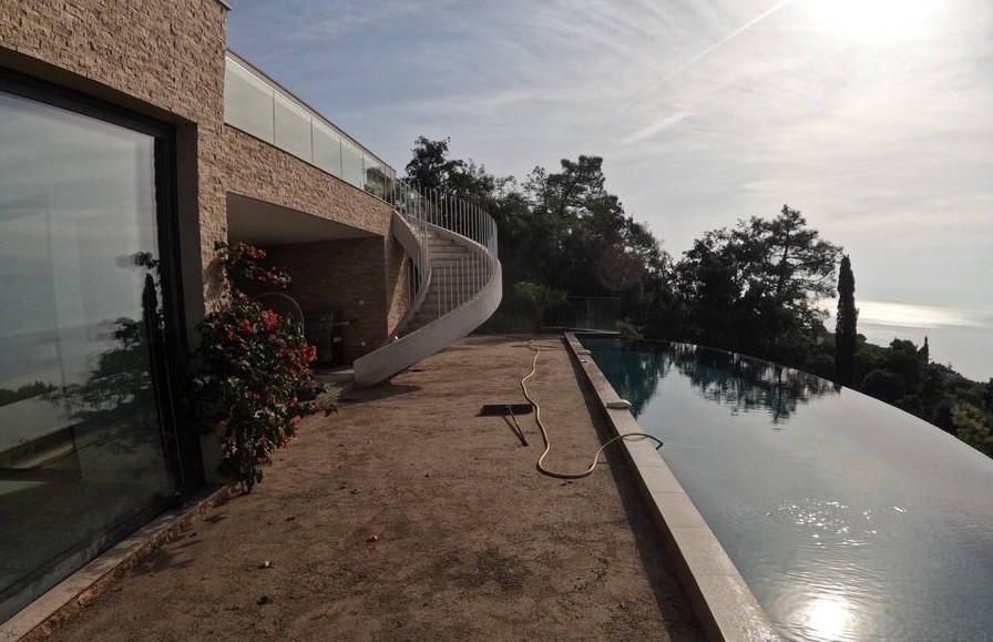 Installation de gazon synthétique AZUR devant une piscine à débordement aux Issambres, près de Fréjus
