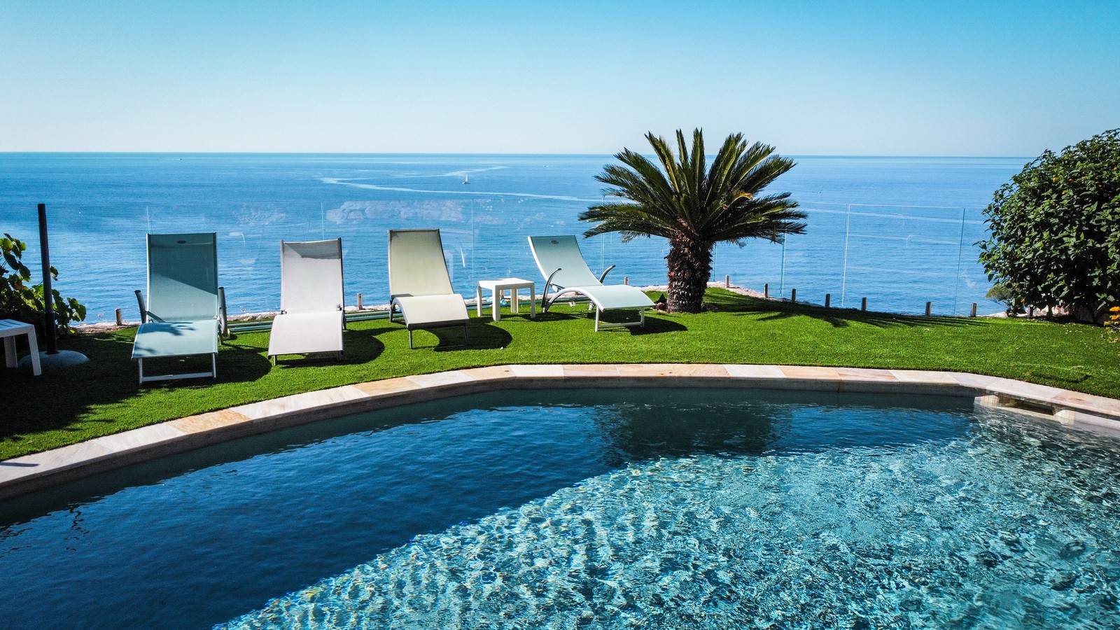 Pose d'un contour de piscine en pelouse synthétique de luxe à flanc de falaise avec vue sur la mer Méditerranée à Nice