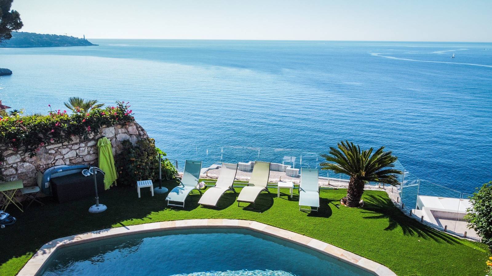 Pose d'un contour de piscine en pelouse synthétique de luxe à flanc de falaise avec vue sur la mer Méditerranée à Nice