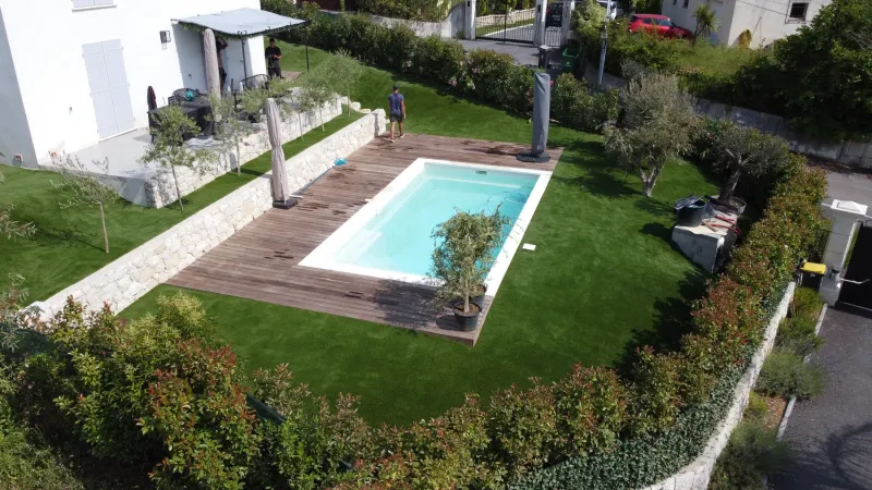 Vue large des trois niveaux après pose complète du gazon synthétique BRAVO 35 mm, jardin en restanques entièrement vert