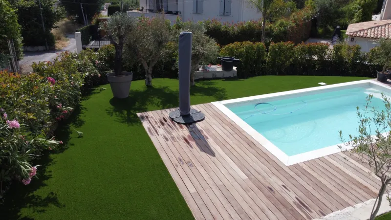 Terrasse et végétation méditerranéenne intégrées dans la pose de gazon synthétique, murs en pierres sèches conservés