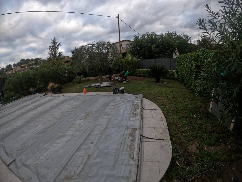 Pose de gazon artificiel de qualité autour d'un arbre avec pas japonais en travertin à La Roquette vers Cannes