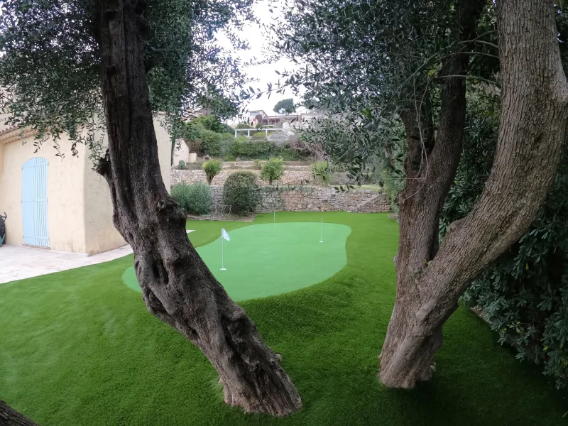 Le putting green encadré par les oliviers centenaires, découpes sur mesure et intégration naturelle dans le jardin de Vallauris.