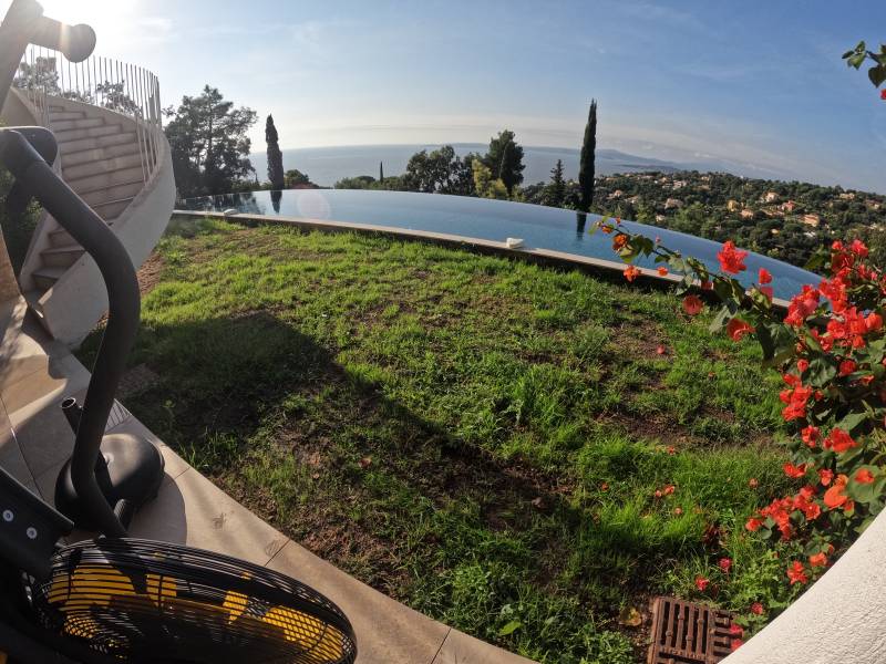 Installation de gazon synthétique AZUR devant une piscine à débordement aux Issambres, près de Fréjus
