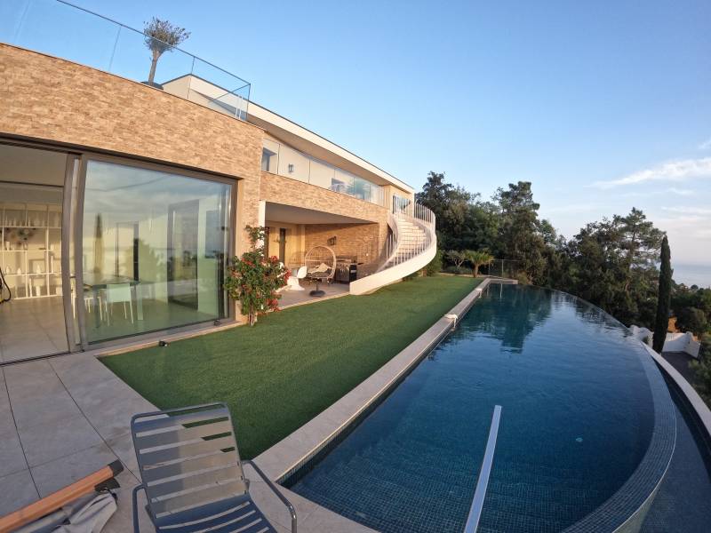 Installation de gazon synthétique AZUR devant une piscine à débordement aux Issambres, près de Fréjus